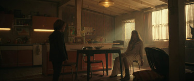 a woman sitting at a table in a kitchen