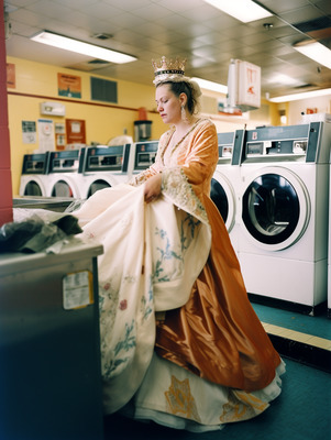 a woman in a dress is standing in front of a washer