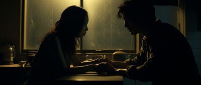 a man and a woman sitting at a table in a dark room