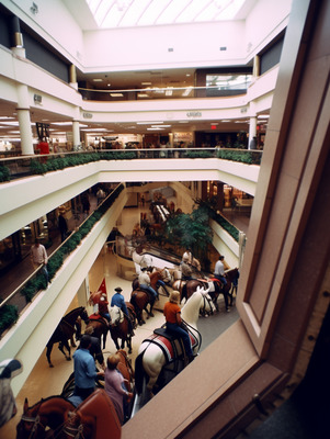 a group of people riding horses inside of a building