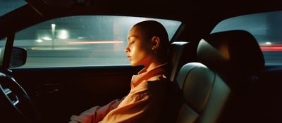 a man sitting in a car in the rain