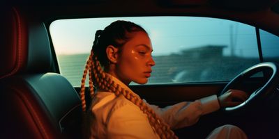 a woman with braids sitting in a car