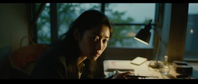 a woman sitting at a desk in front of a window