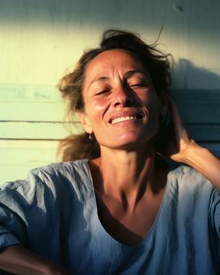 a woman smiling and holding her hair in the wind