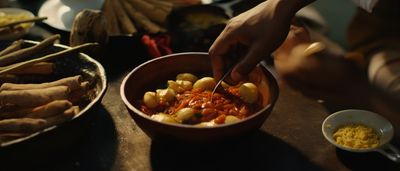 a person cutting food in a bowl on a table