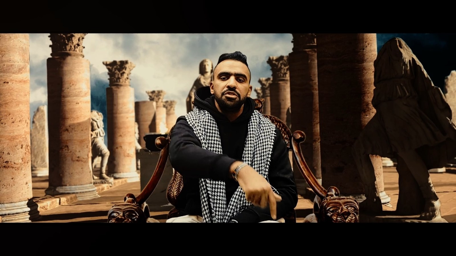 a man sitting on a chair in front of columns