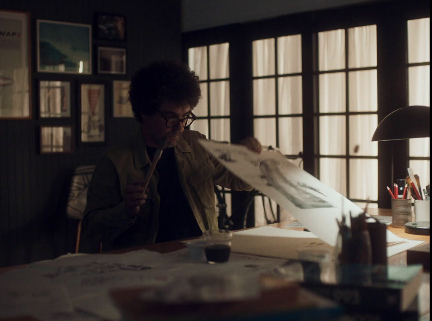 a man holding a piece of paper while sitting at a desk