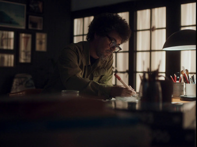 a man sitting at a desk writing on a piece of paper