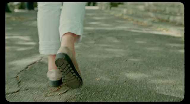 a person walking down a sidewalk with their shoes on