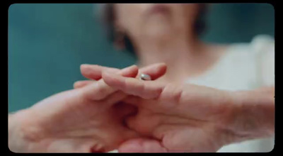 a woman holding a wedding ring in her hands