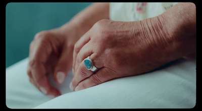 a close up of a person's hand holding a ring