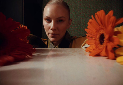 a woman sitting at a table with flowers in front of her