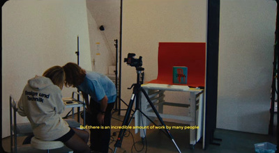 a woman is sitting on a chair in front of a camera