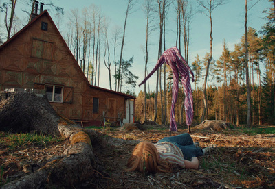 a woman laying on the ground in front of a house