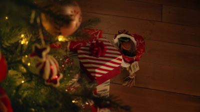 a christmas tree with a gift wrapped in red and white paper