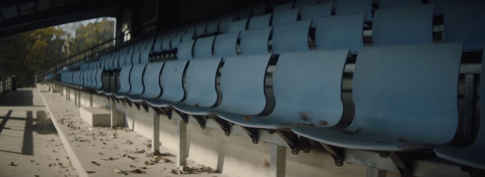 a row of empty blue seats in a stadium