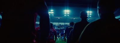 a group of people standing around a soccer field