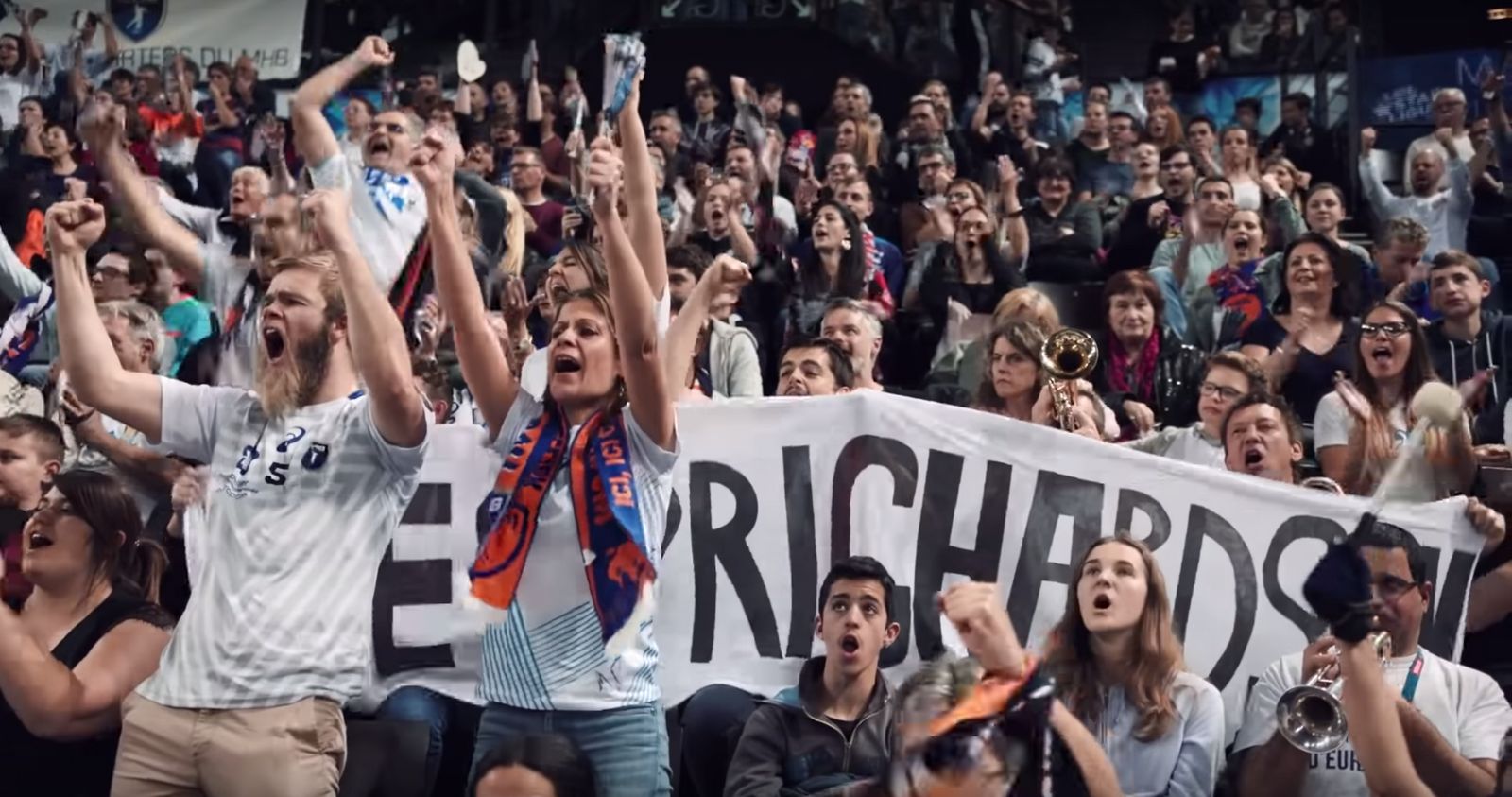 a group of people holding up signs in front of a crowd