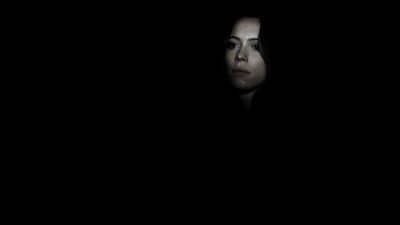 a woman in a dark room with a black background