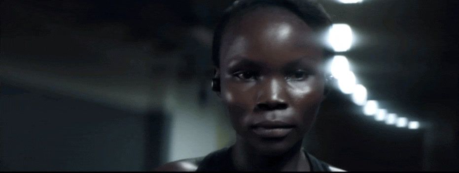 a woman is staring at the camera in a dark room