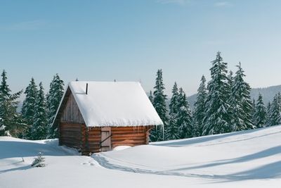 a small cabin in the middle of a snowy field