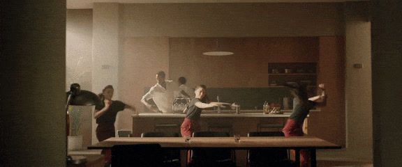 a group of people standing around a kitchen