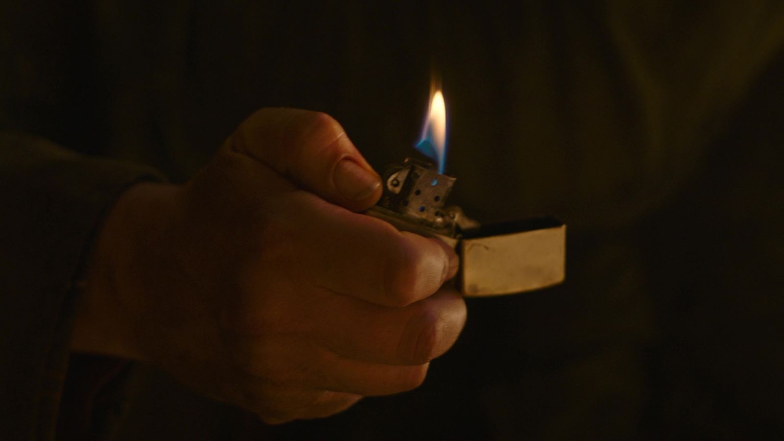 a person holding a lighter in their hand