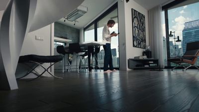 a man standing in a living room next to a window