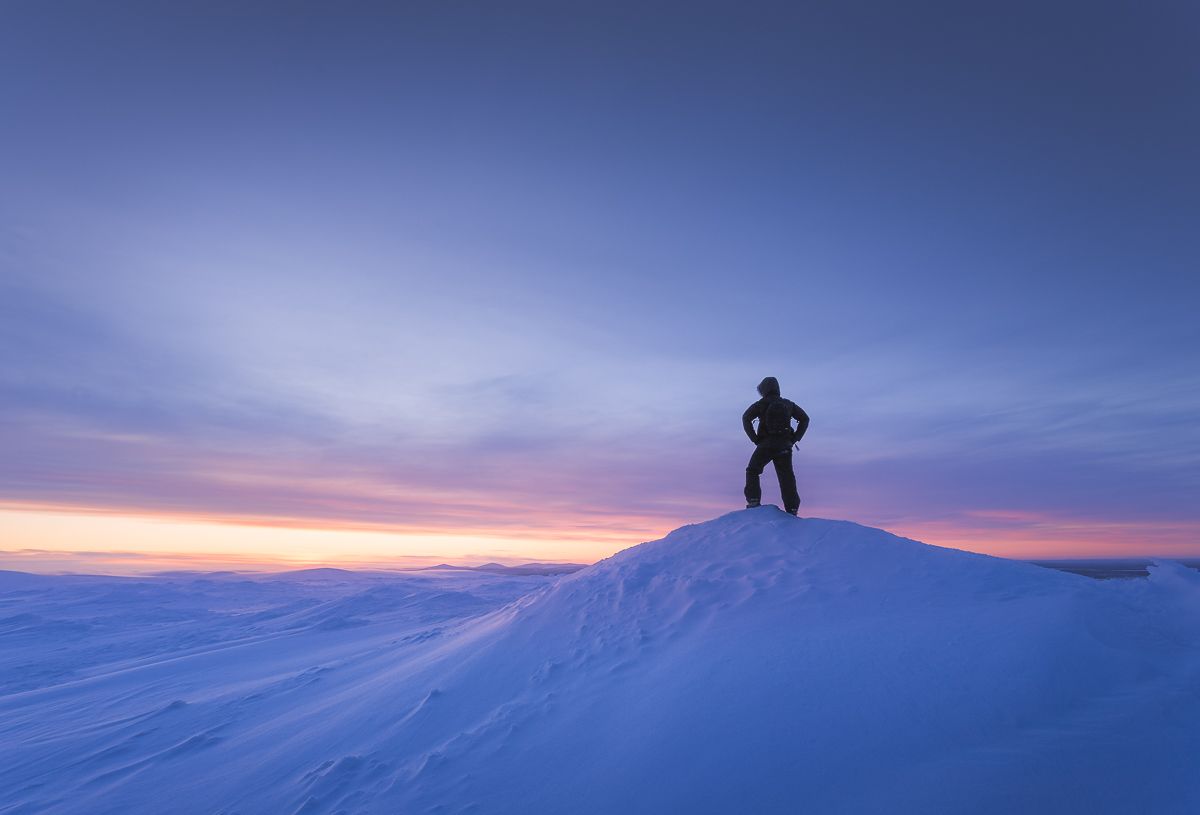 a man standing on top of a snow covered hill