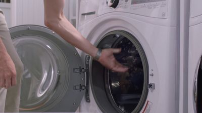 a person is loading a washing machine into a washer