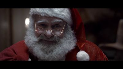 a man with glasses and a beard wearing a santa suit