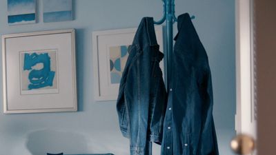 a blue room with a coat rack and pictures on the wall