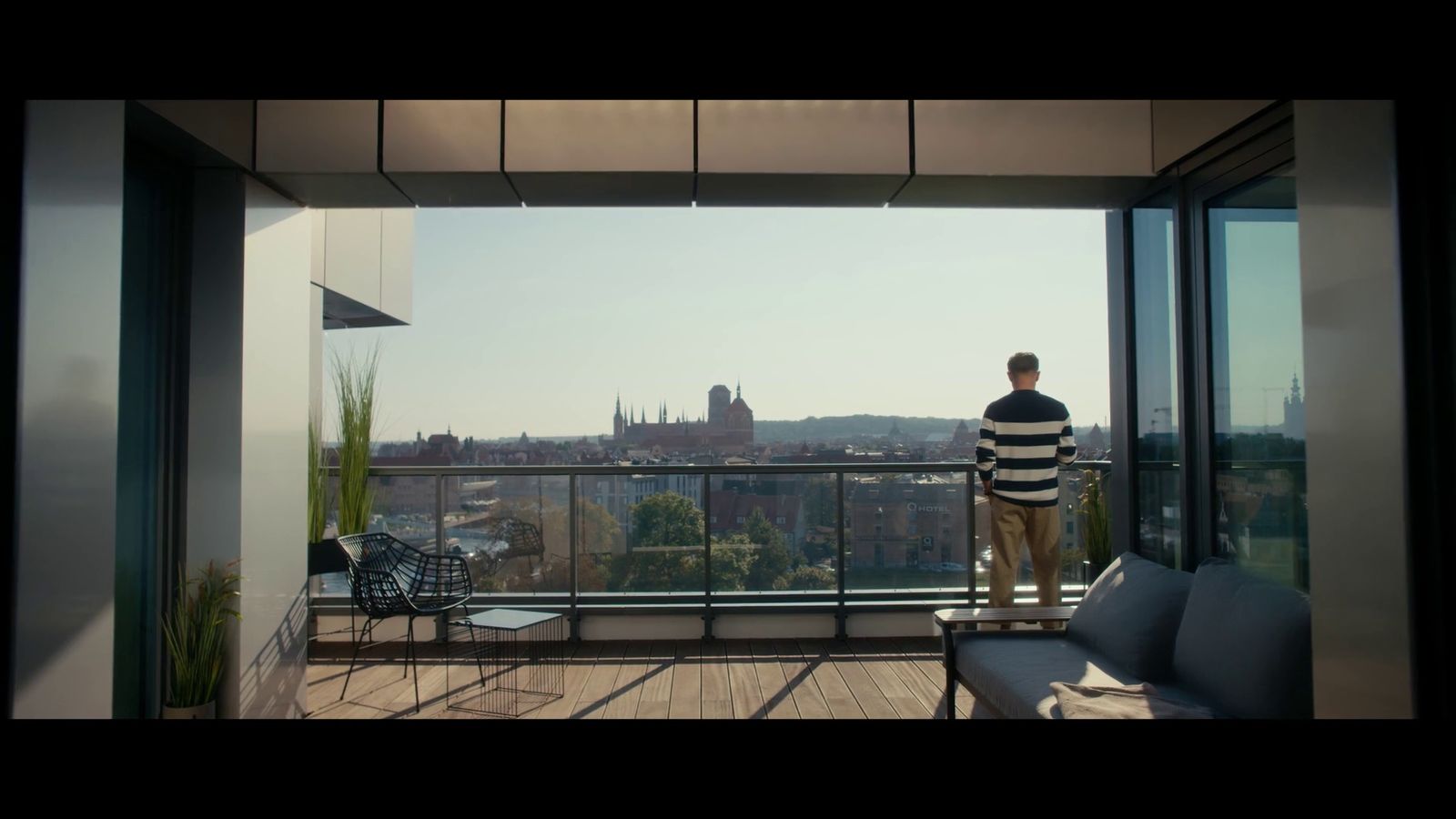 a man standing on a balcony overlooking a city