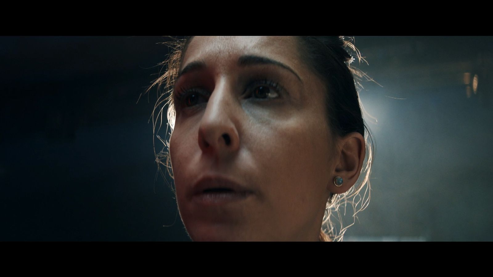 a close up of a woman's face in the dark