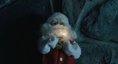 a close up of a santa clause holding a light