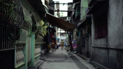 a narrow alley way with people walking down it