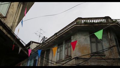 a building with a bunch of colorful flags hanging from it's side