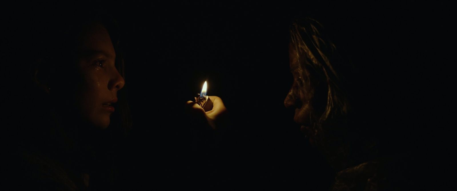 a woman holding a lit cigarette in the dark