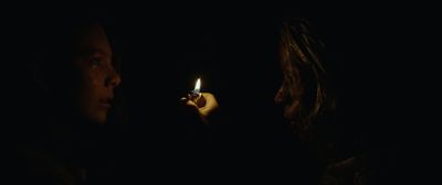 a woman holding a lit cigarette in the dark