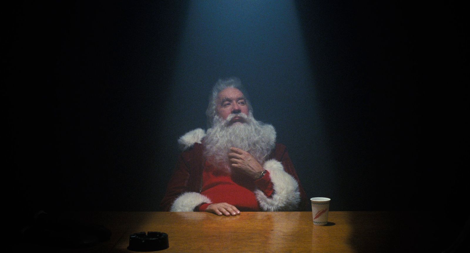 a man dressed as santa claus sitting at a table