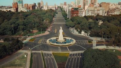 an aerial view of a city with a statue in the middle