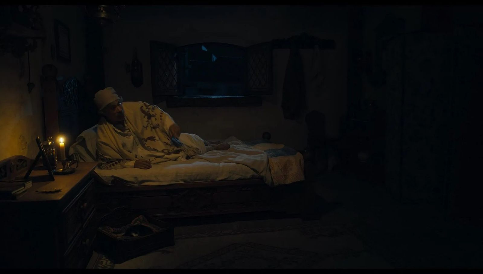 a man sitting on a bed in a dark room