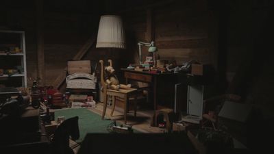 a cluttered room with a bed and a desk