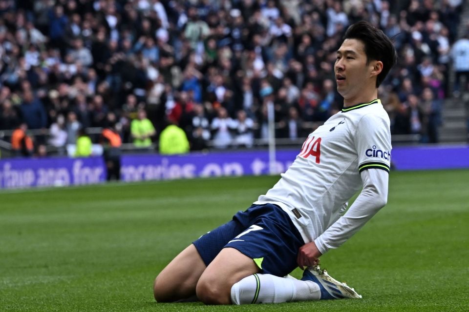 a soccer player laying on the ground in front of a crowd