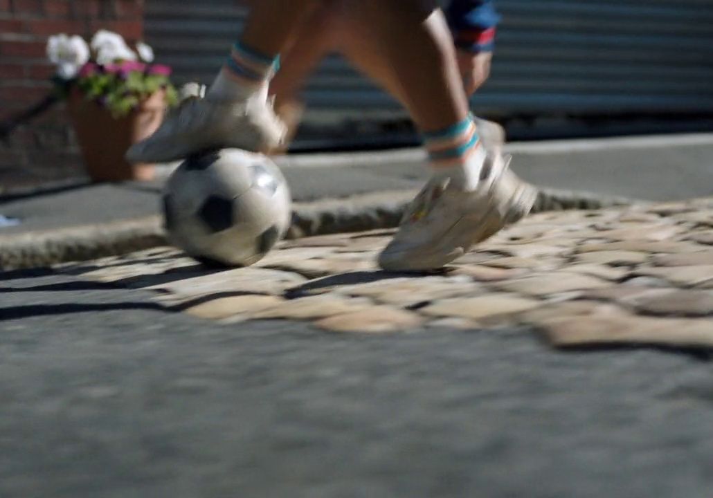 a person kicking a soccer ball on a street