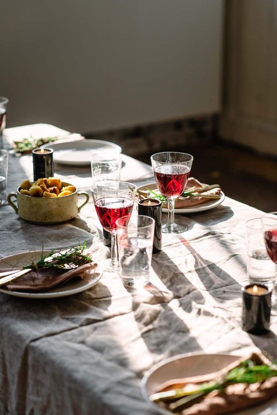 a table with plates of food and glasses of wine