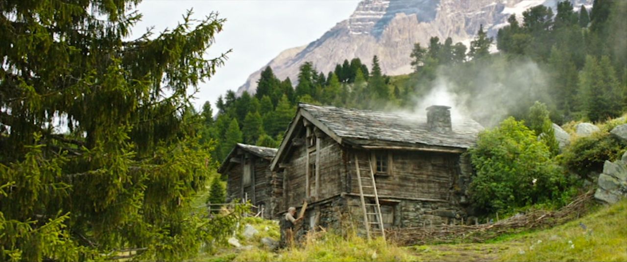 an old wooden cabin in the mountains with smoke coming out of it