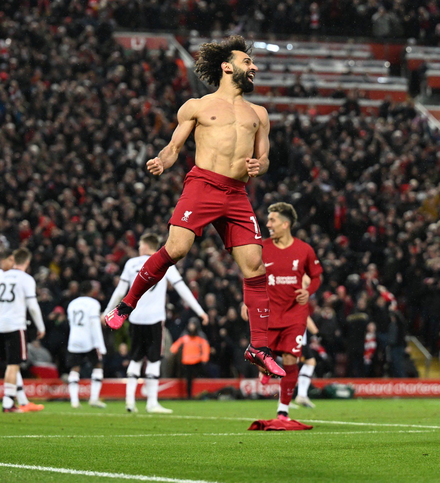 a shirtless man is running on a soccer field