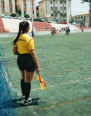 a girl in a yellow shirt is standing on a soccer field