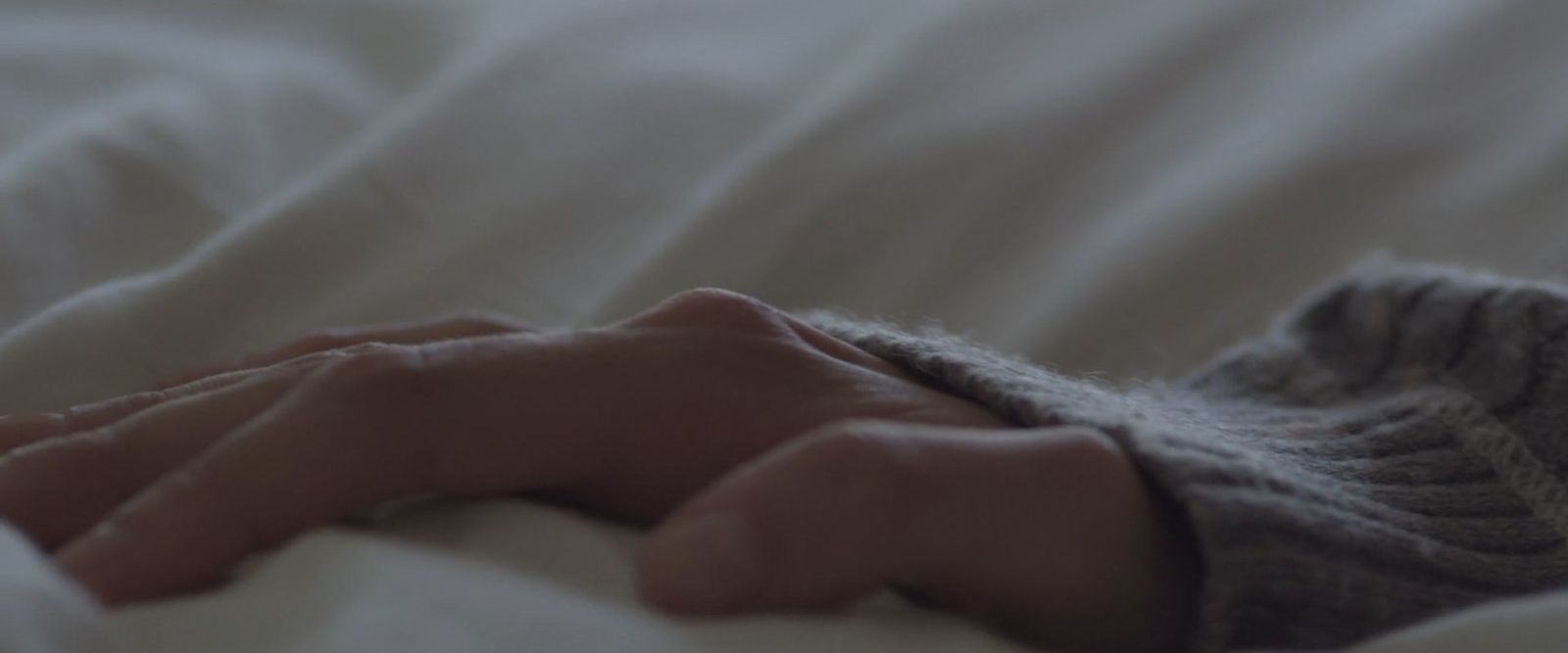 a close up of a person's hand on a bed